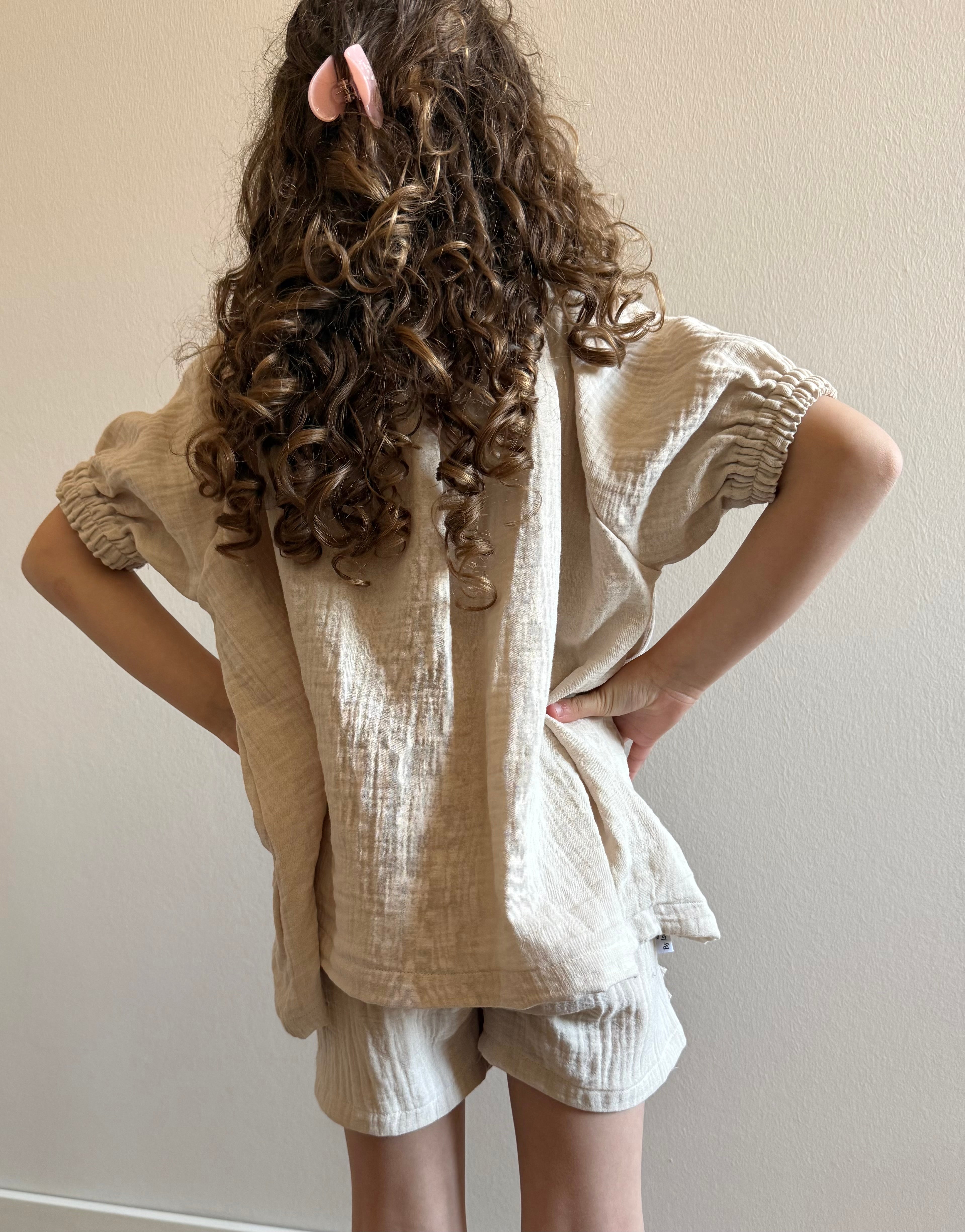 achterkant model met mousseline broekje en blouse in beige kleur