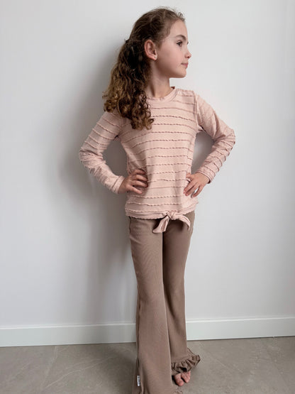roze ruffle shirt met taupe flared broekje op model