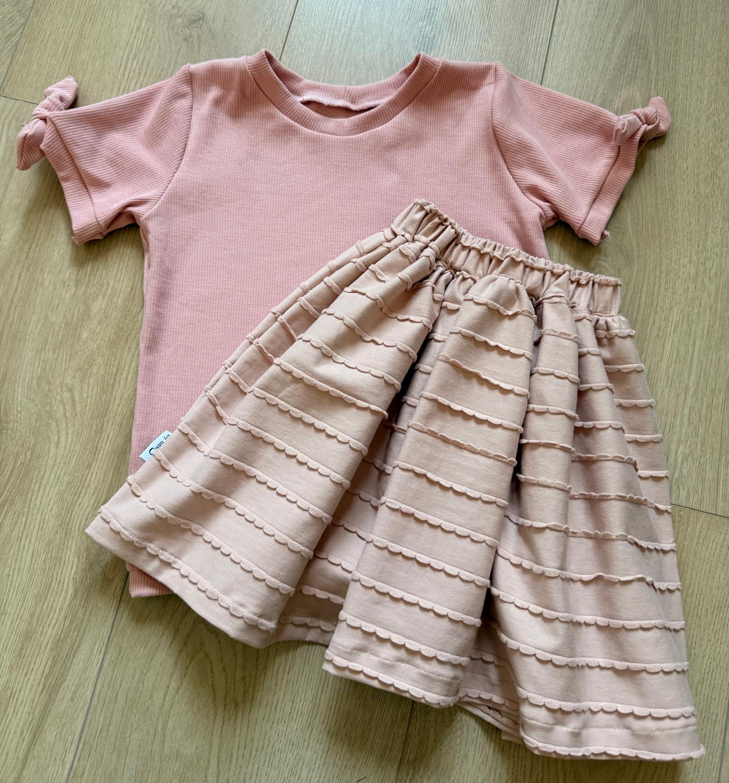 flatlay foto van ruffle rokje en korte mouw shirt roze