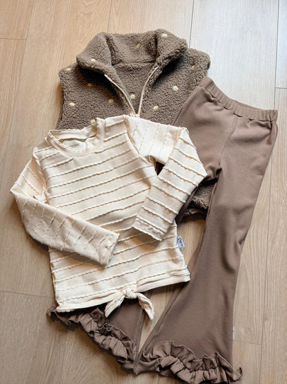 flatlay foto met bodywarmer taupe met taupe flared broek en shirt ruffle ecru