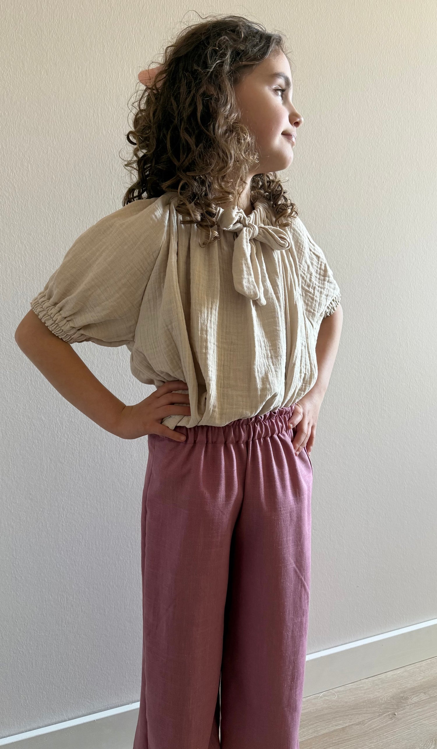 model met linnenbroek roze en mousseline blouse beige