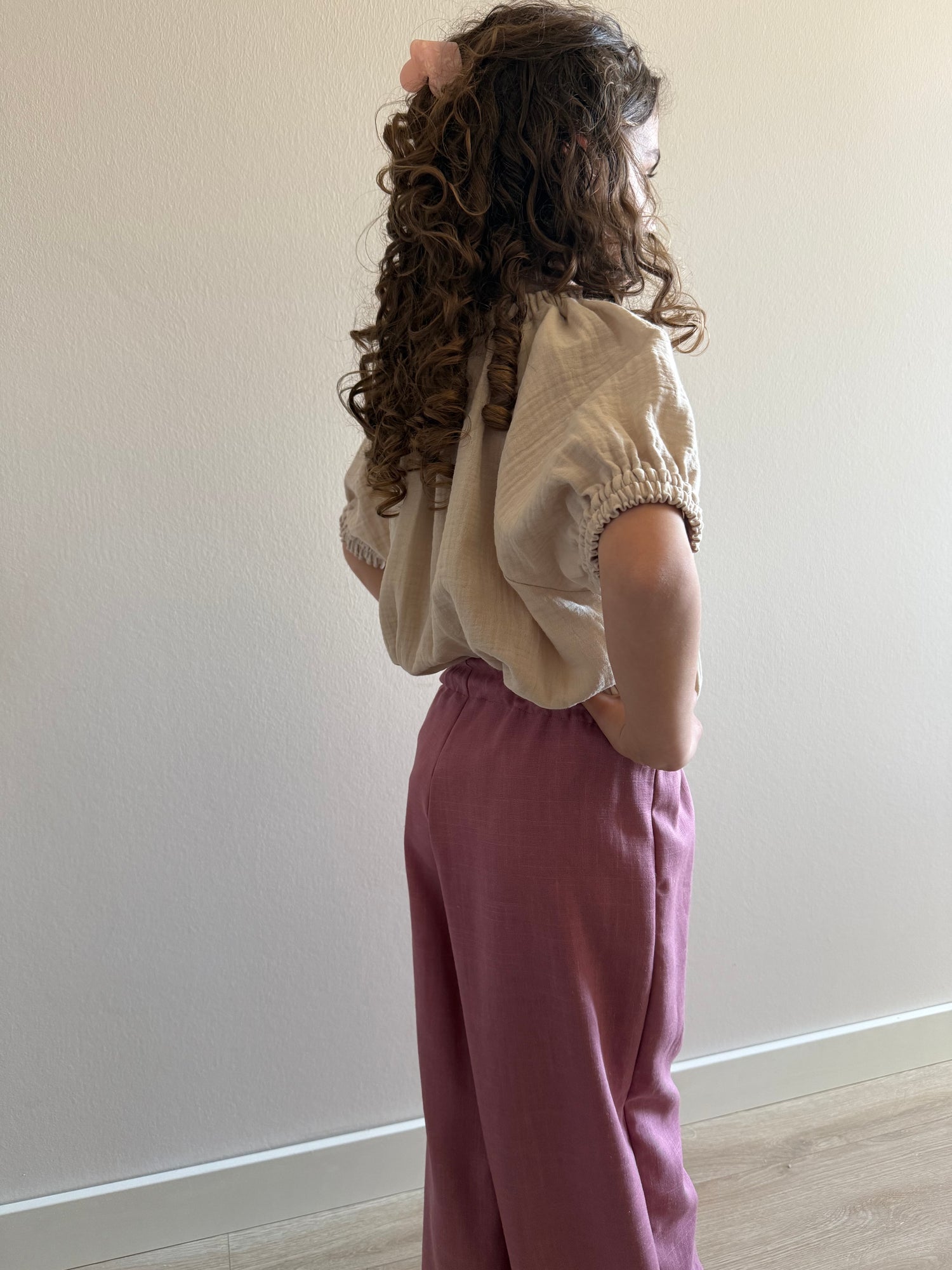 zijkant model linnen broek roze en mousseline shirt beige