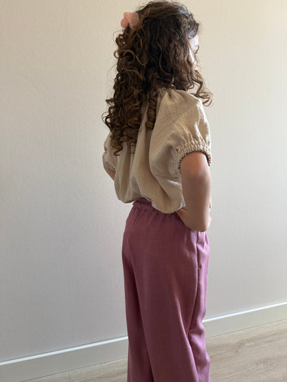zijkant model linnen broek roze en mousseline shirt beige