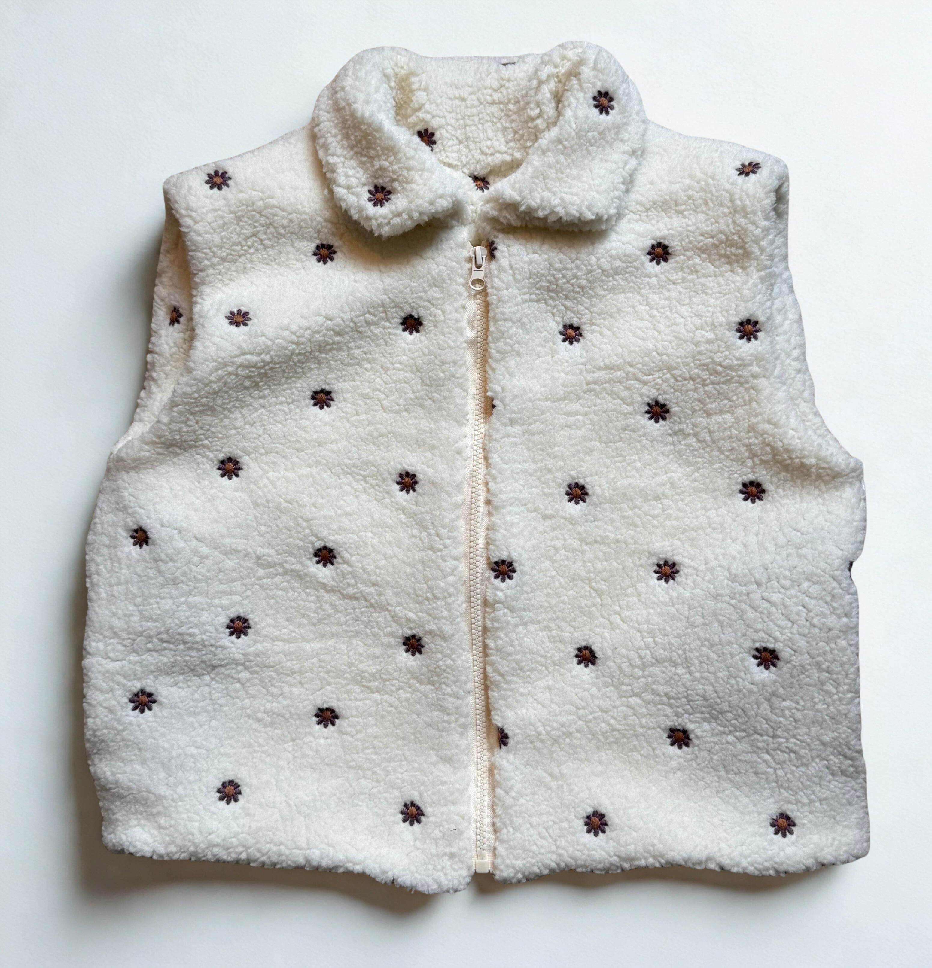 bodywarmer met rits ecru met aubergine madeliefjes geborduurd