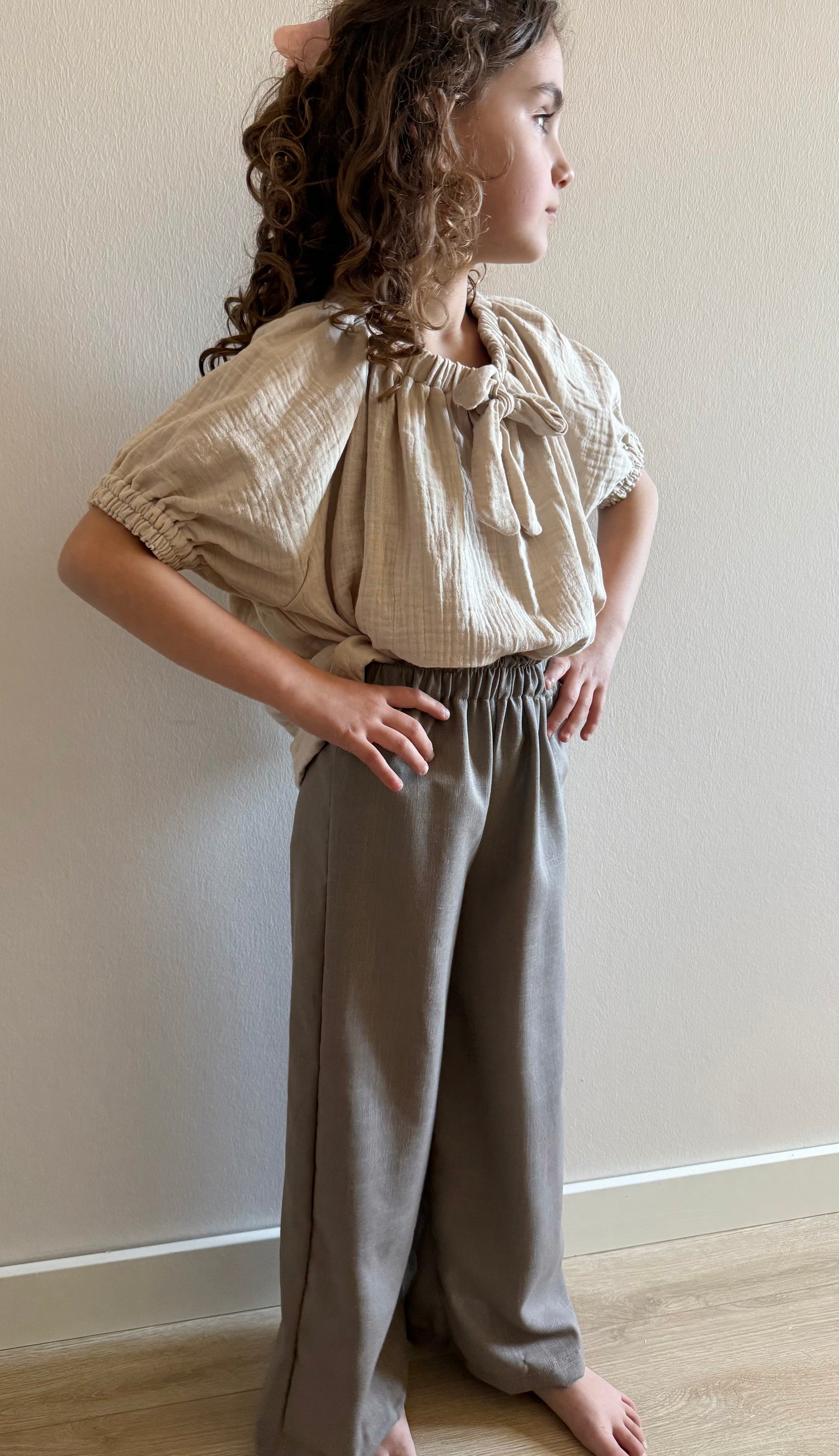 model staand met linnen broek taupe en beige mousseline blouse 