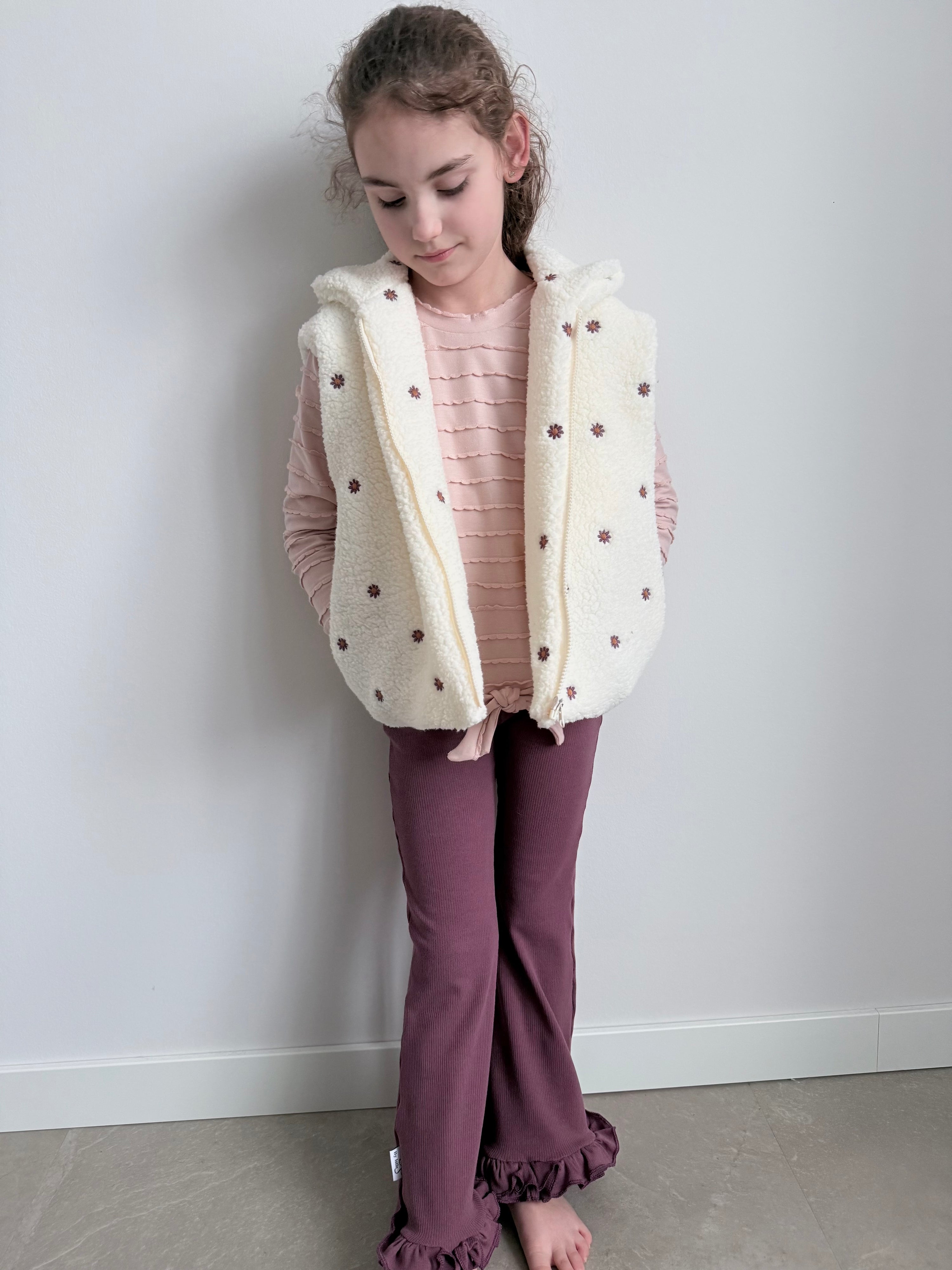 Model met bodywarmer ecru met aubergine madeliefjes 