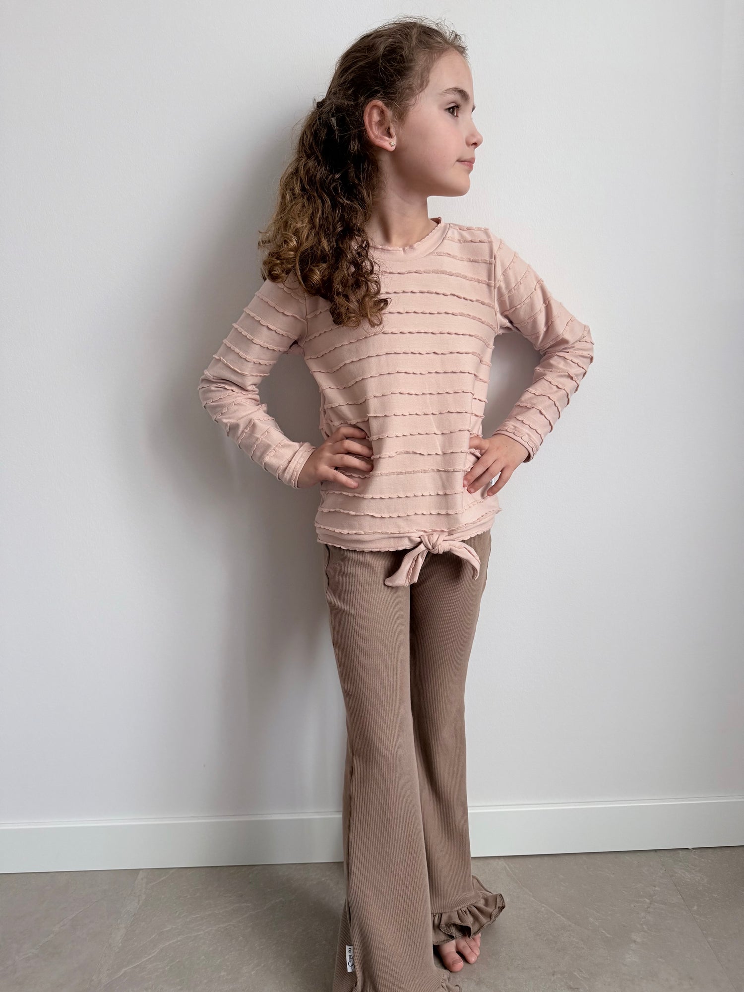 modelfoto met ruffle shirt roze en flared broekje taupe 