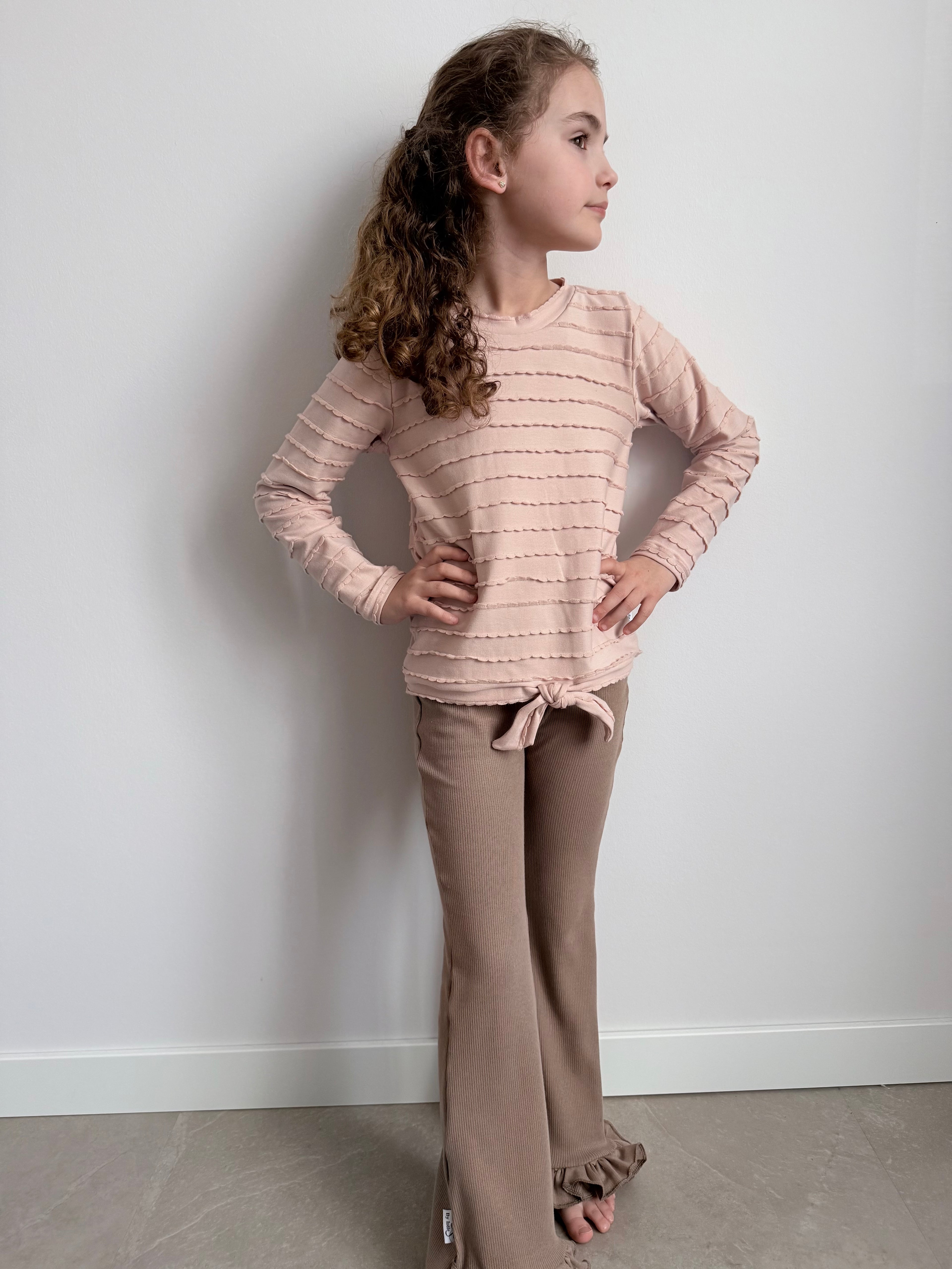 modelfoto met ruffle shirt roze en flared broekje taupe 