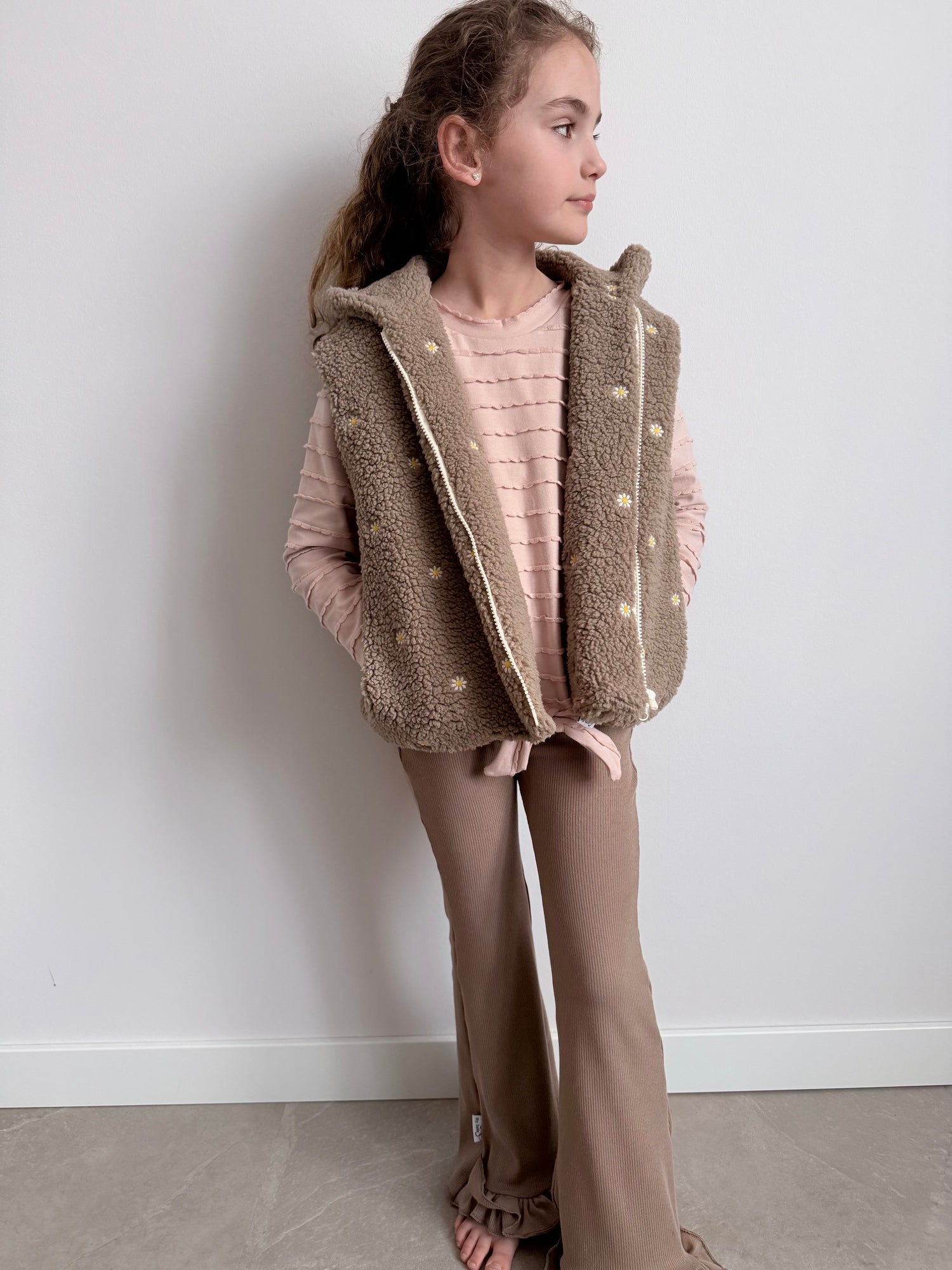 flared broekje taupe met roze ruffle shirt en taupe bodywarmer op model